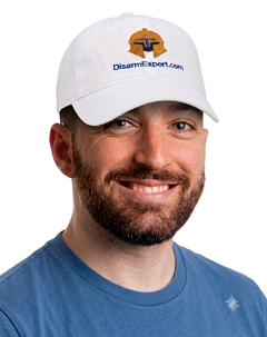 Smiling bearded man in white DisarmExpert cap