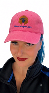 Smiling person wearing pink logo baseball cap