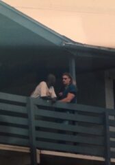 Two people sitting on balcony railing